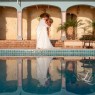 Bride and groom Kiss with reflection in pool
