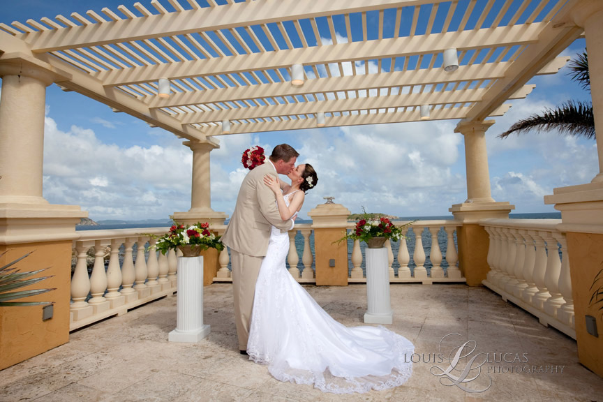 Bride and groom kiss under the caribbean sky