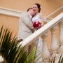 Bride laughs with excitement as grooms kisses her neck