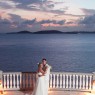 Bride and groom hold one another with sea in background